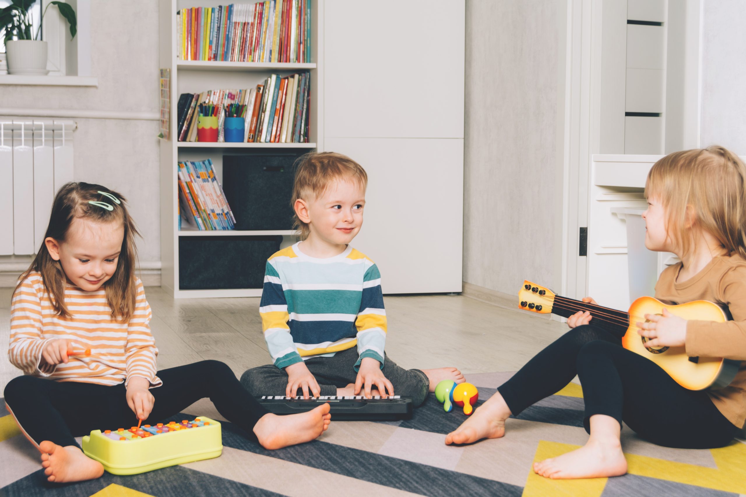 Smiling children playing musical instruments at home